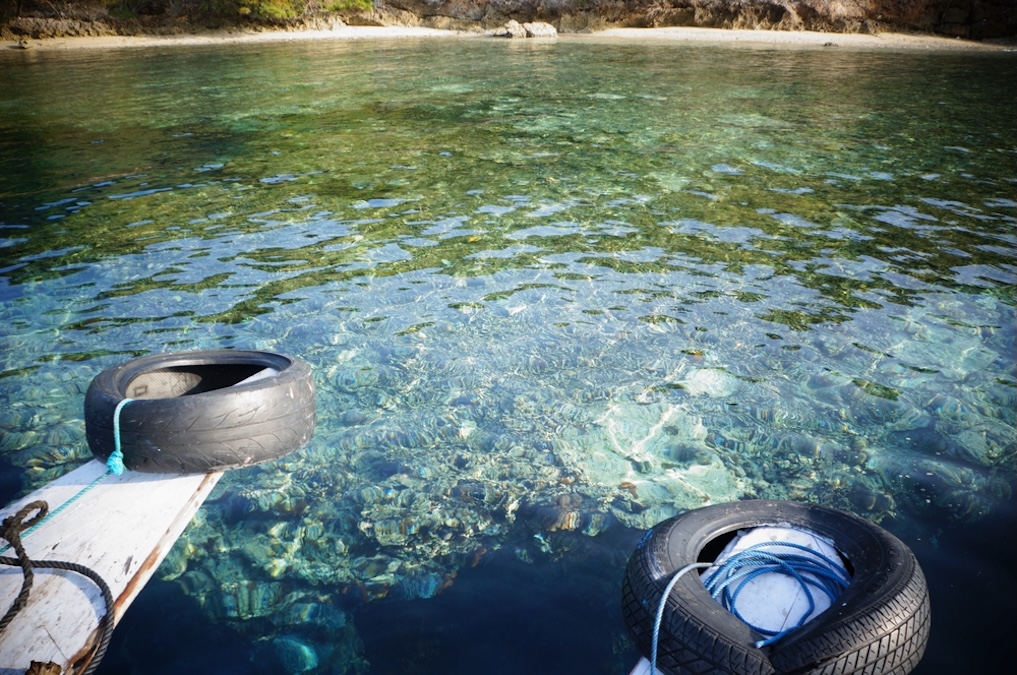Old tire on the edge of a boat and coral reef