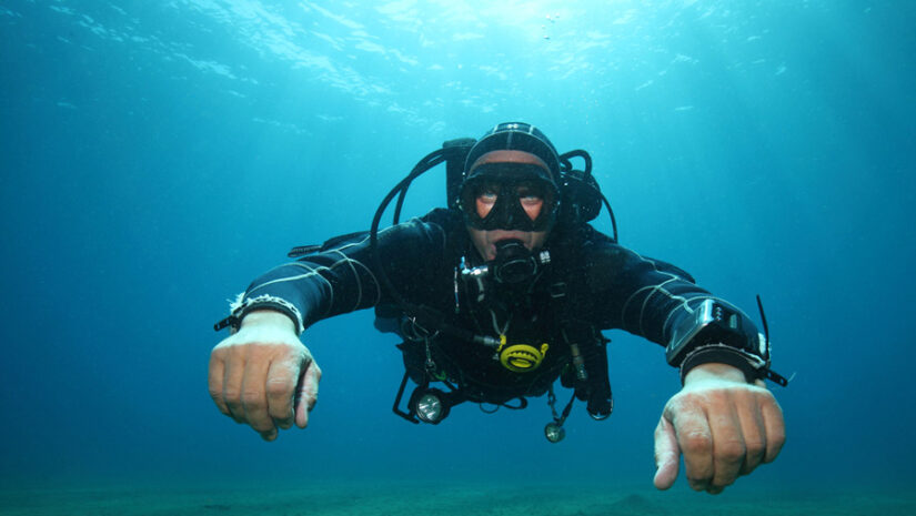 man wearing a drysuit underwater