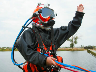 commercial diver preparing to submerge himself into the water
