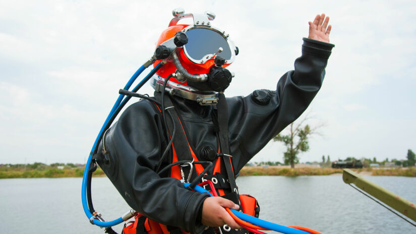 commercial diver preparing to submerge himself into the water