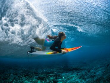 woman surfing in rash guard