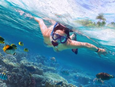 young woman snorkeling in a coral reef