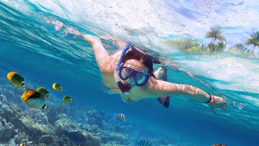 young woman snorkeling in a coral reef