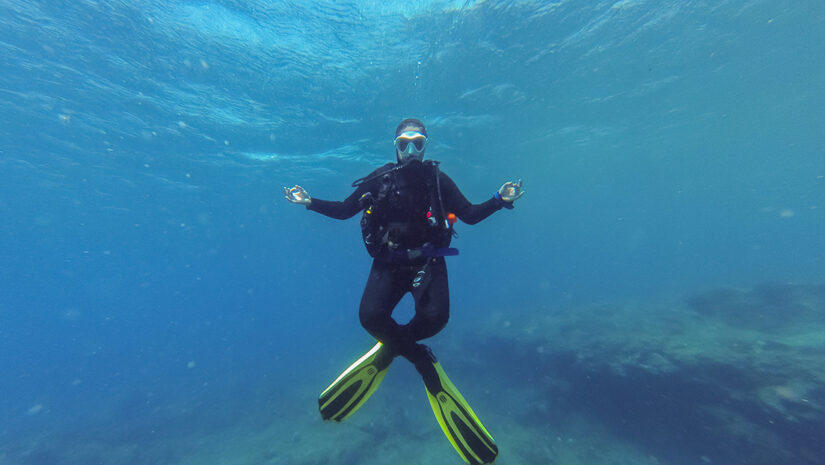 Young female scuba diver in the lotus yoga position during a dive in Atlantic ocean