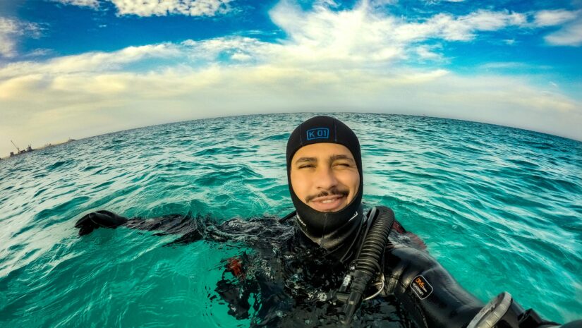 man wearing dive compass smiles at camera