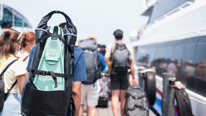 a-man-with-diving-fins-and-snorkel-bag-walking-out-of-a-boat-via-adobe-stock By chartphoto