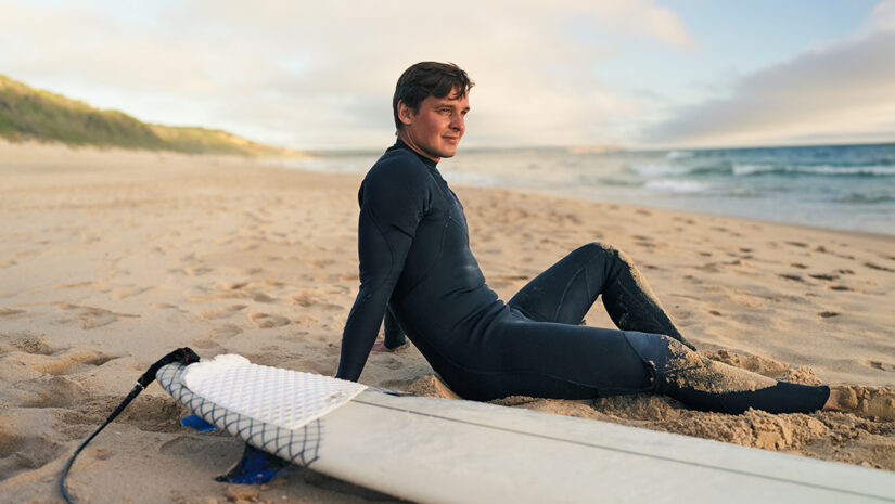 man on beach wearing a wetsuit