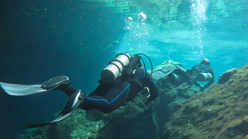 Two divers exploring the cenotes in Mexico - Underwater at cenot