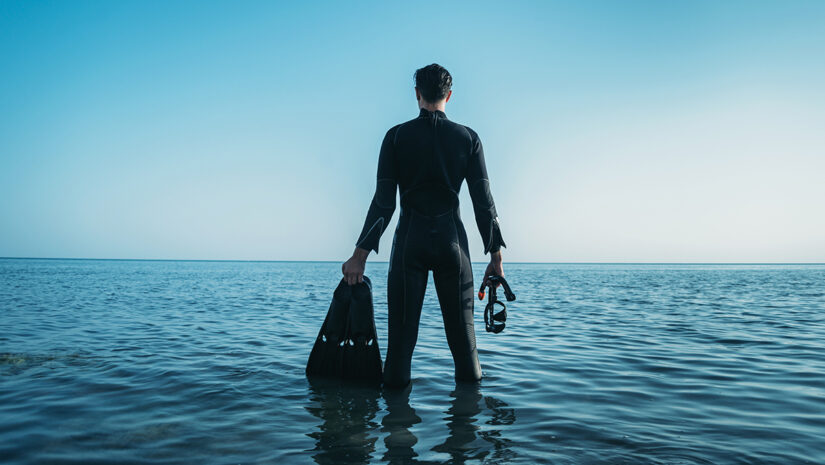 Diver man standing in the cold sea By Alex Photo