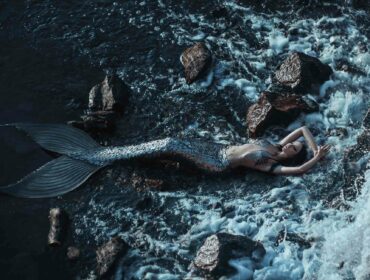 alluring mermaid reclining on the rocks