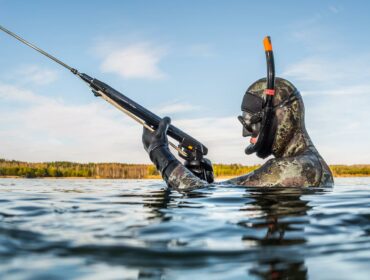 Spearfisher holding speargun above water