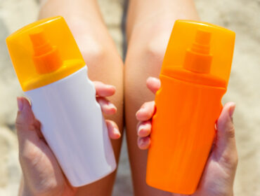 Woman holding two kinds of sun protectants