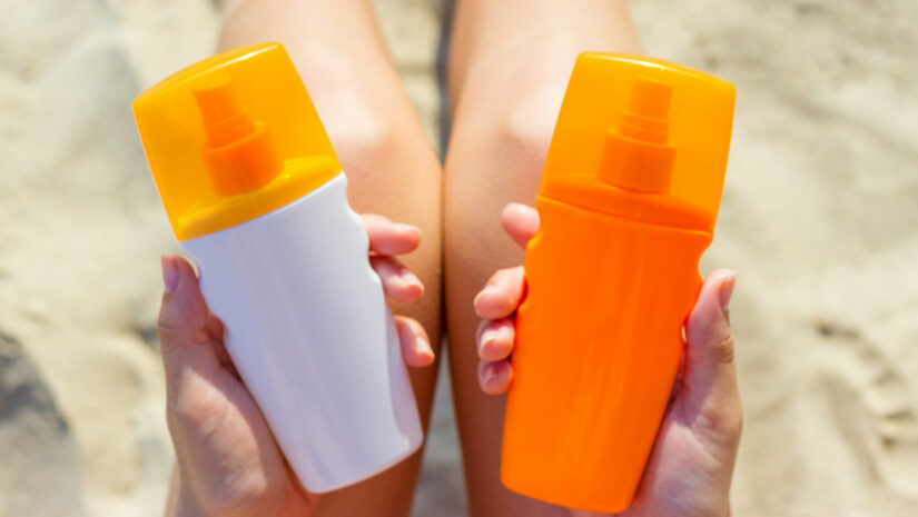 Woman holding two kinds of sun protectants