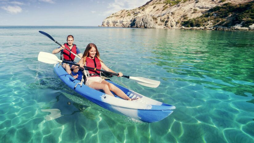 Couple kayaking in clear blue green waters