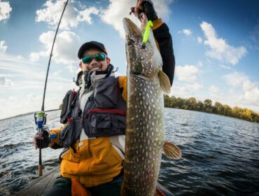 man holding up big fish after fishing