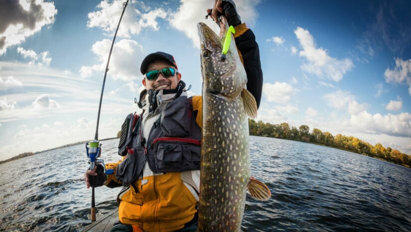 man holding up big fish after fishing