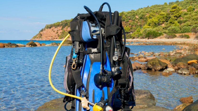 scuba diving gear package with fins on a rock near the water