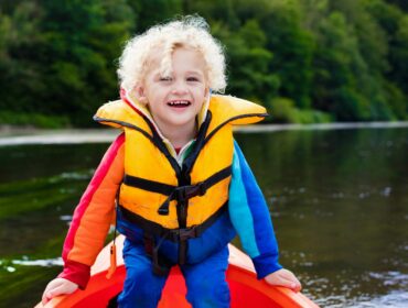 young boy in a boat wearing life jacket