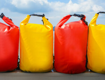 a row of bright yellow and red waterproof dry bags