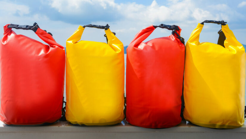 a row of bright yellow and red waterproof dry bags