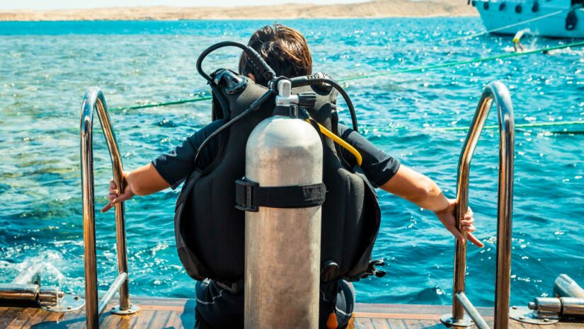 Scuba diver on edge of platform right before diving into the water