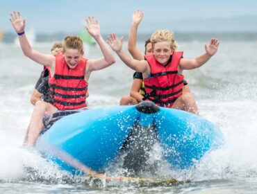 kids riding a towable tube in the ocean