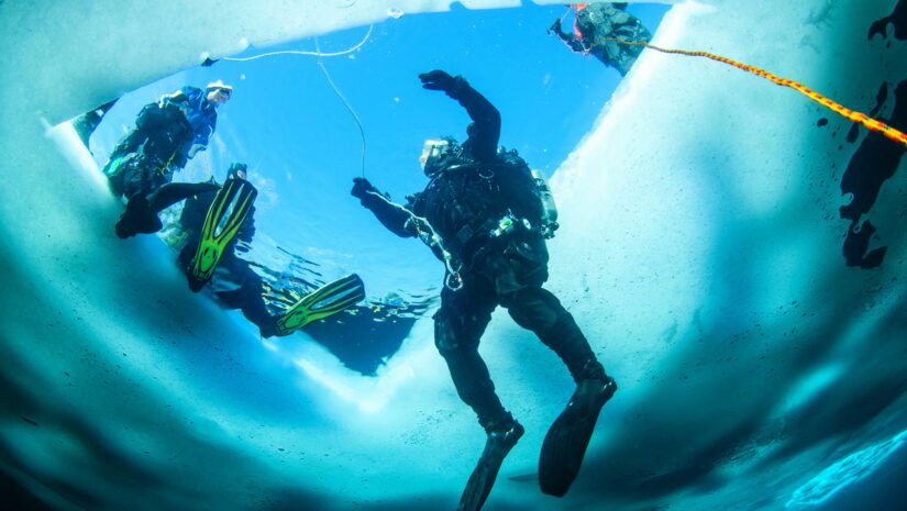 scuba diver inside icy lake