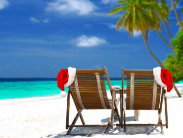 beach chairs with Santa hats by the shore