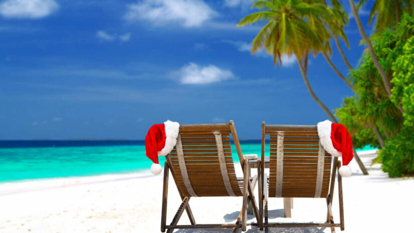 beach chairs with Santa hats by the shore