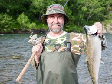 fisherman showing off freshly caught salmon