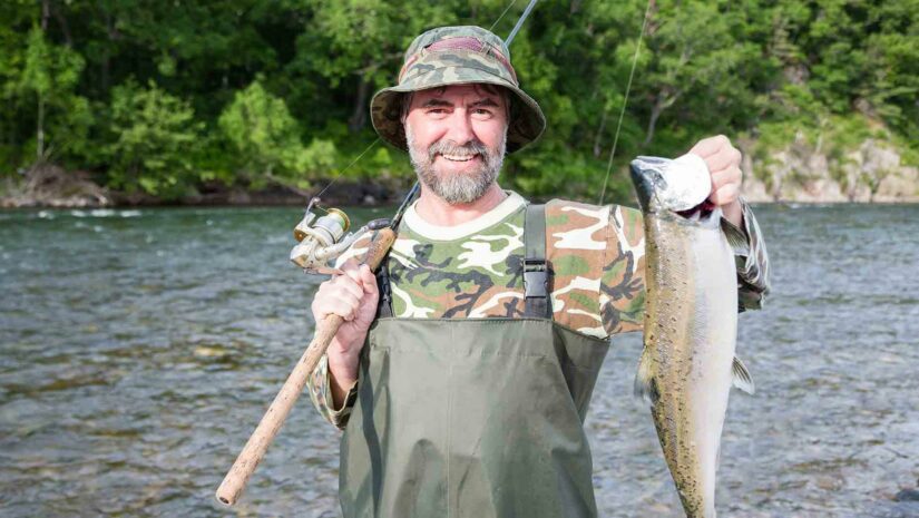 fisherman showing off freshly caught salmon