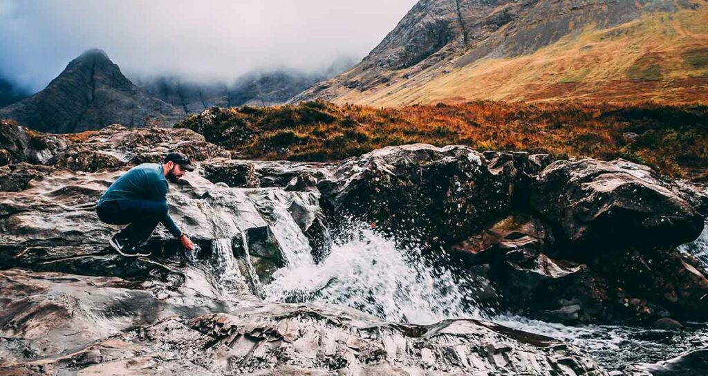 man getting water from the stream