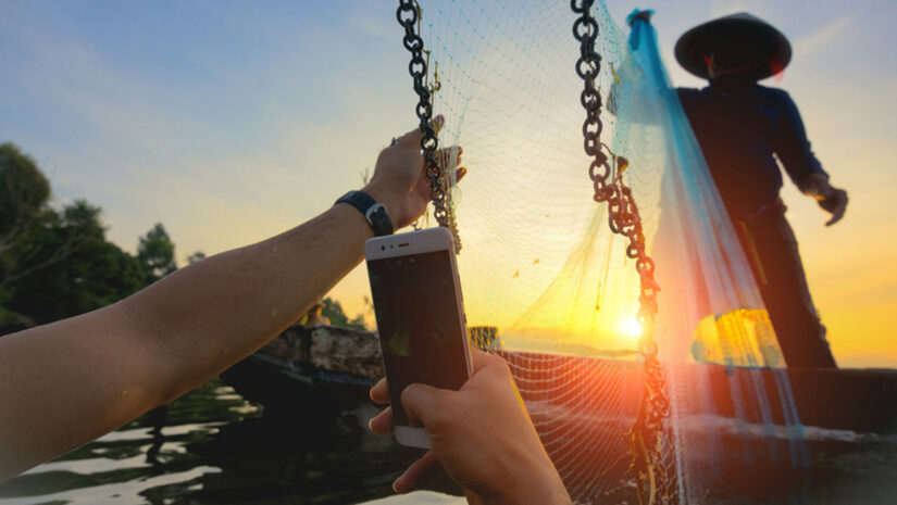 swimmer taking a photo of a fisherman