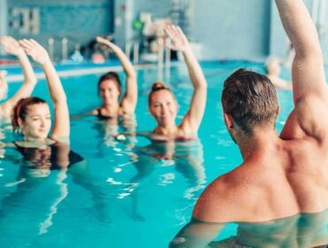 water aerobics class doing arm stretches