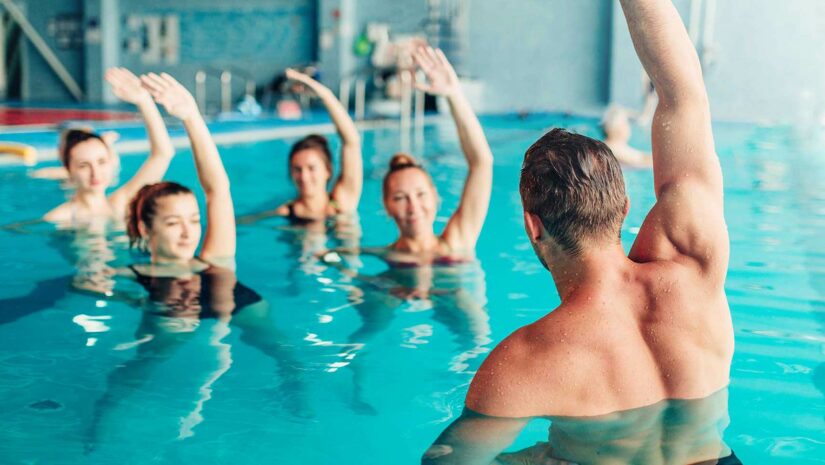 water aerobics class doing arm stretches