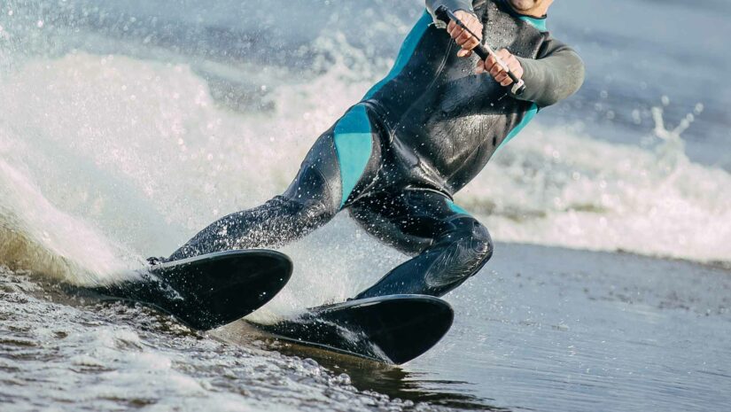 a man water skiing with combo skis