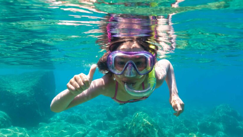 a young girl wearing snorkeling gear