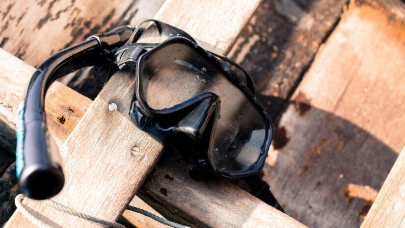 a scuba mask resting on wood