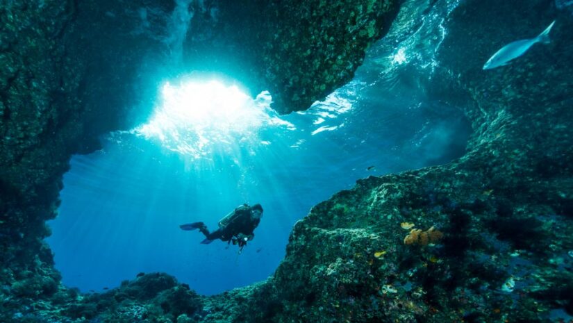 diver swimming in an underwater cavern