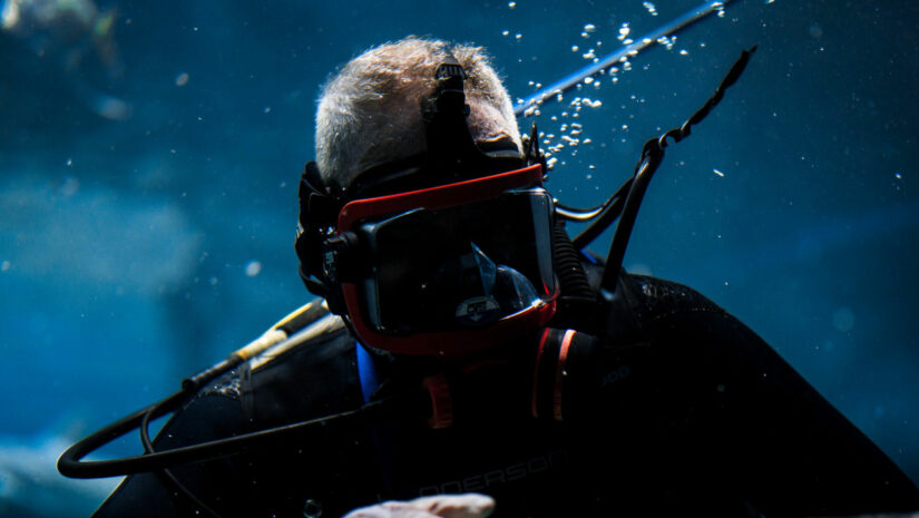 close-up of a diver wearing scuba gear and a tight wetsuit