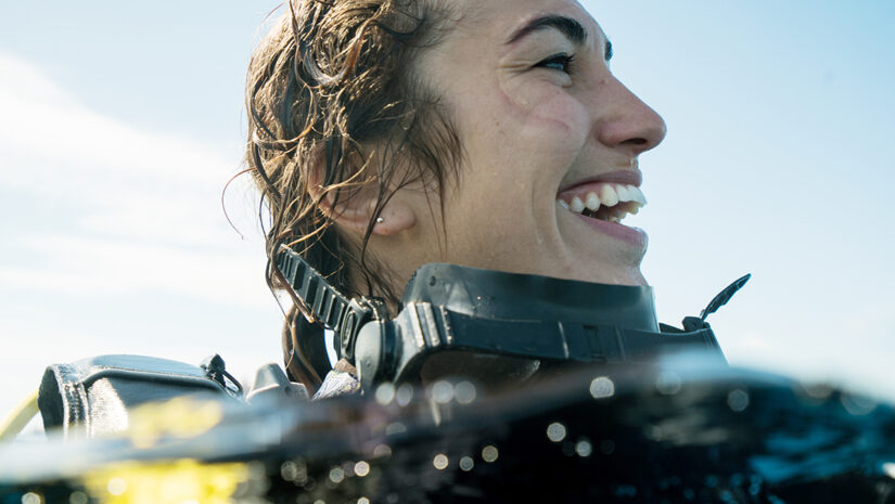 Woman Smiling while Scuba Diving with joyful toothy grin during
