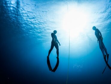 freedivers in water with freediving line