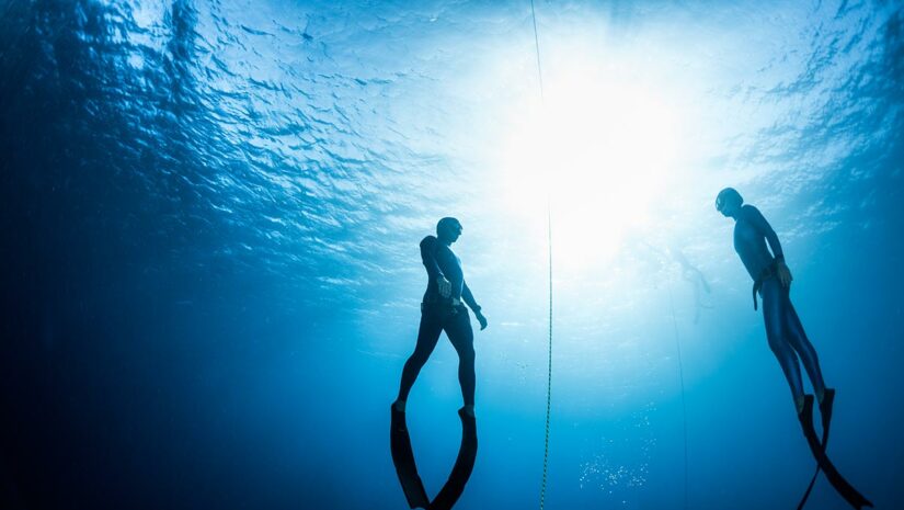 freedivers in water with freediving line