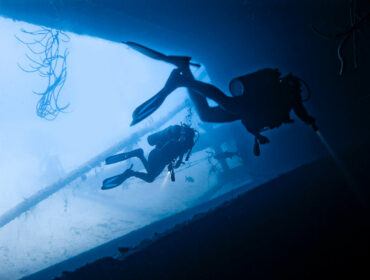 two scuba divers in dive wreck