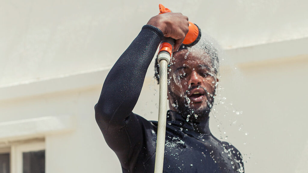 man diver rinsing wetsuit