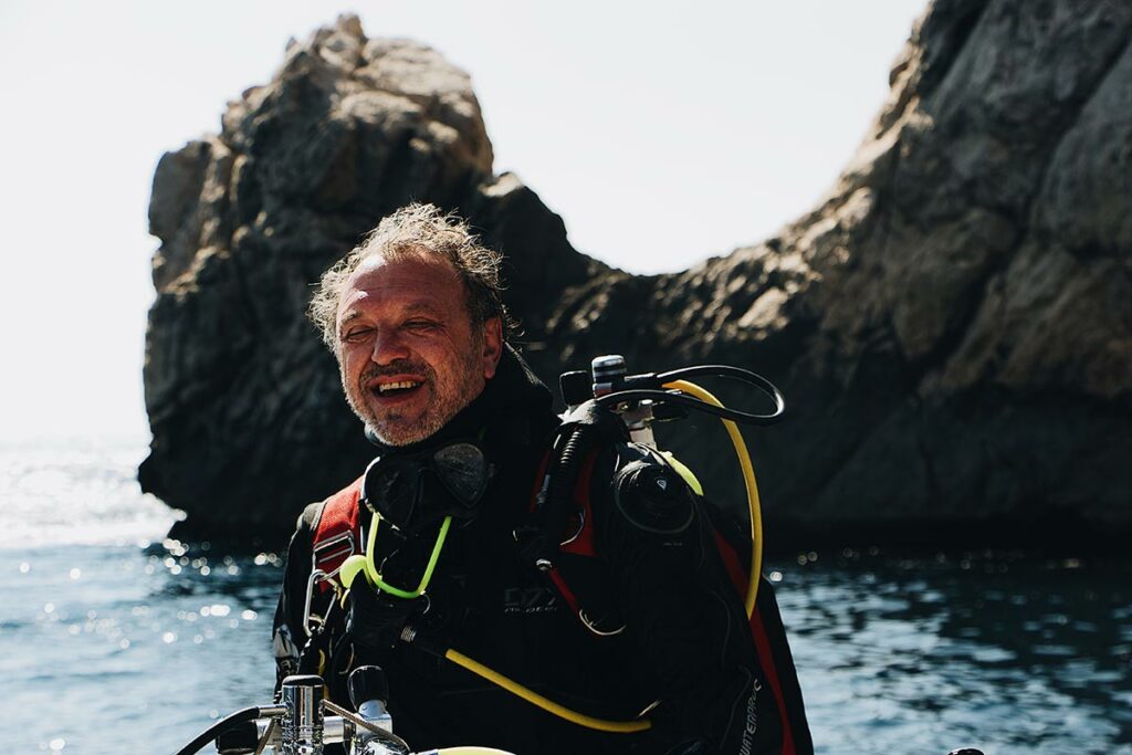 scuba diver on beach with gear