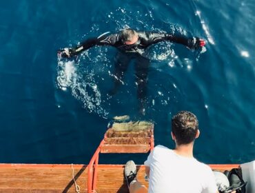 scuba diver surfacing next to boat