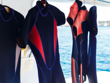 scuba diving wetsuits hanging on boat