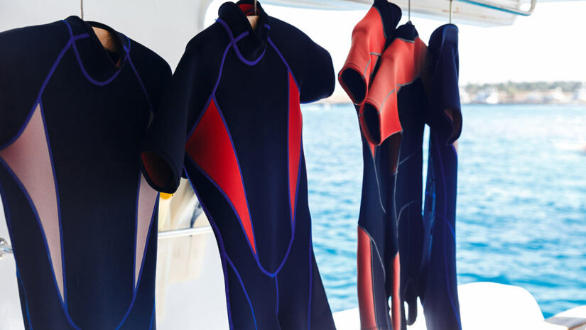scuba diving wetsuits hanging on boat