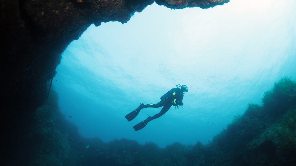 scuba diver underwater in reef cave